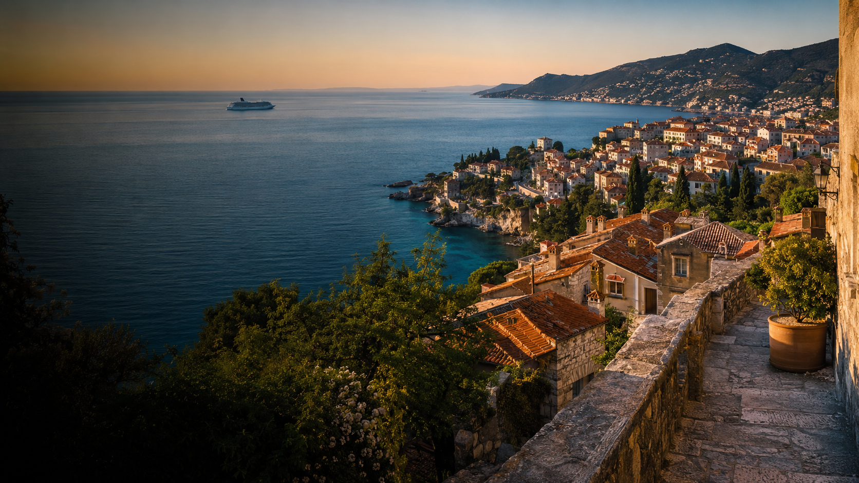 A coastal European town overlooking the sea at golden hour